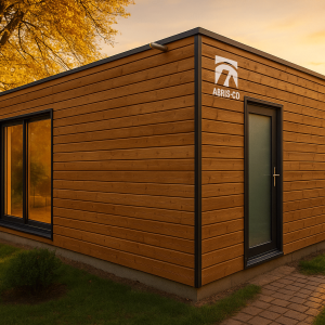 Kit studio de jardin en ossature bois dans un jardin en France, avec bardage naturel et toiture moderne au coucher du soleil